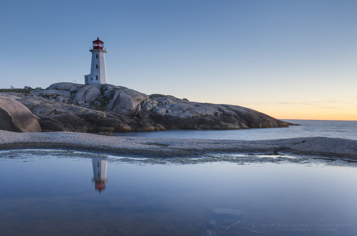 Peggy's Cove Lighthouse reflected in pool of water on granite shoreline, Nova Scotia #58894