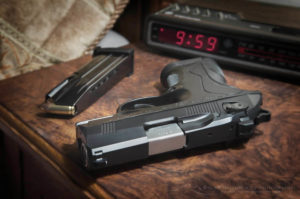 Beretta 9mm Px4 Storm semi-automatic pistol home defense. On bedside nightstand with book and reading glasses
