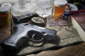 Beretta PX4 Storm semi-automatic pistol with 9mm ammunition on bedroom nightstand with prescription medication