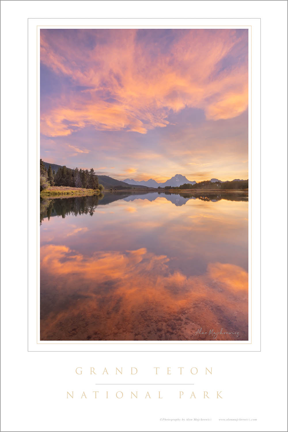 Clouds glowing red and orange in the light of the setting sun reflected in still waters of the Snake River at Oxbow Bend, Grand Teton National Park Wyoming