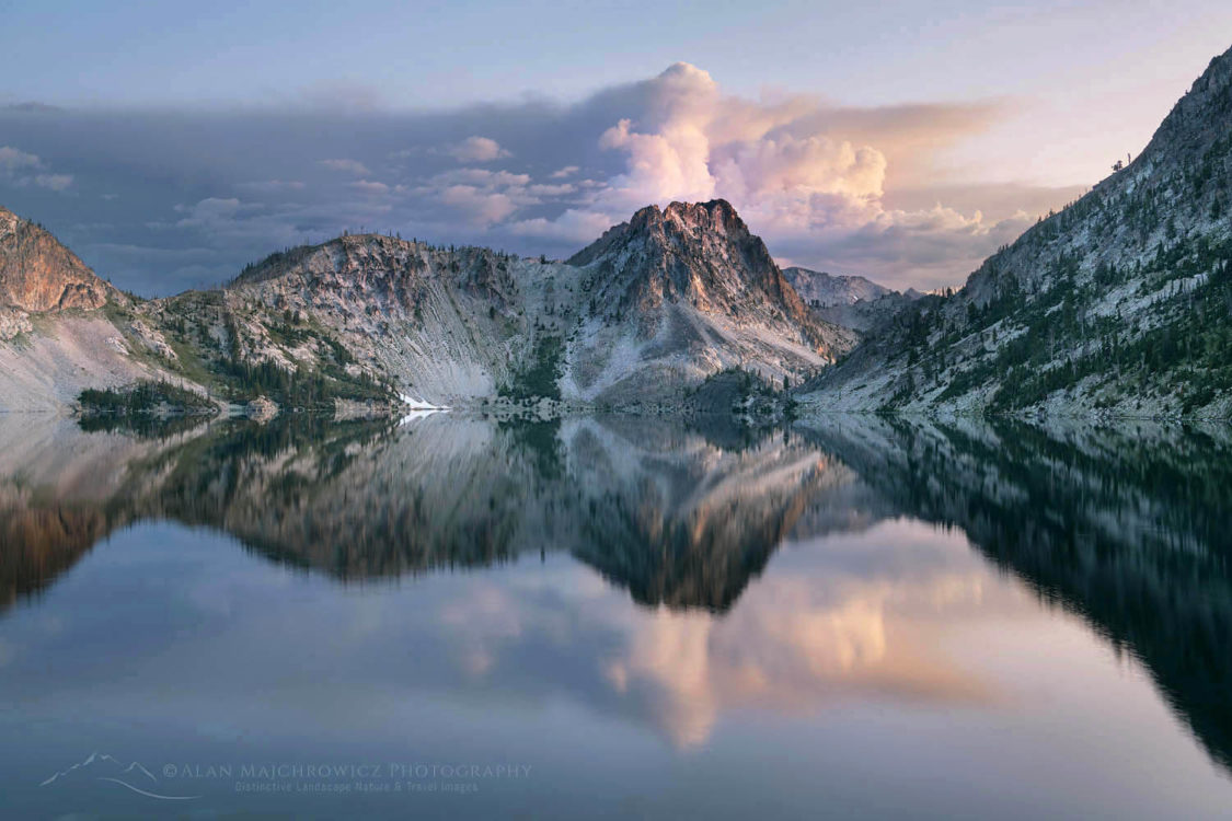 Morning clouds mirrored in still waters of Sawtooth Lake. Sawtooth Mountains Wilderness Idaho
