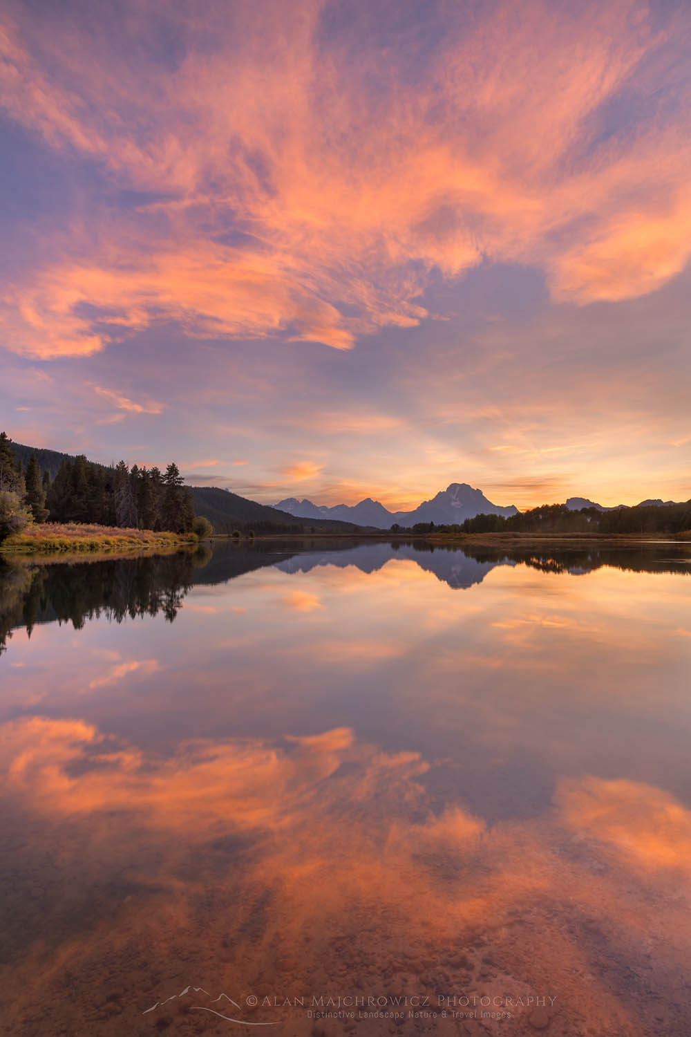 Clouds glowing red and orange in the light of the setting sun reflected in still waters of the Snake River at Oxbow Bend, Grand Teton National Park Wyoming #67566
