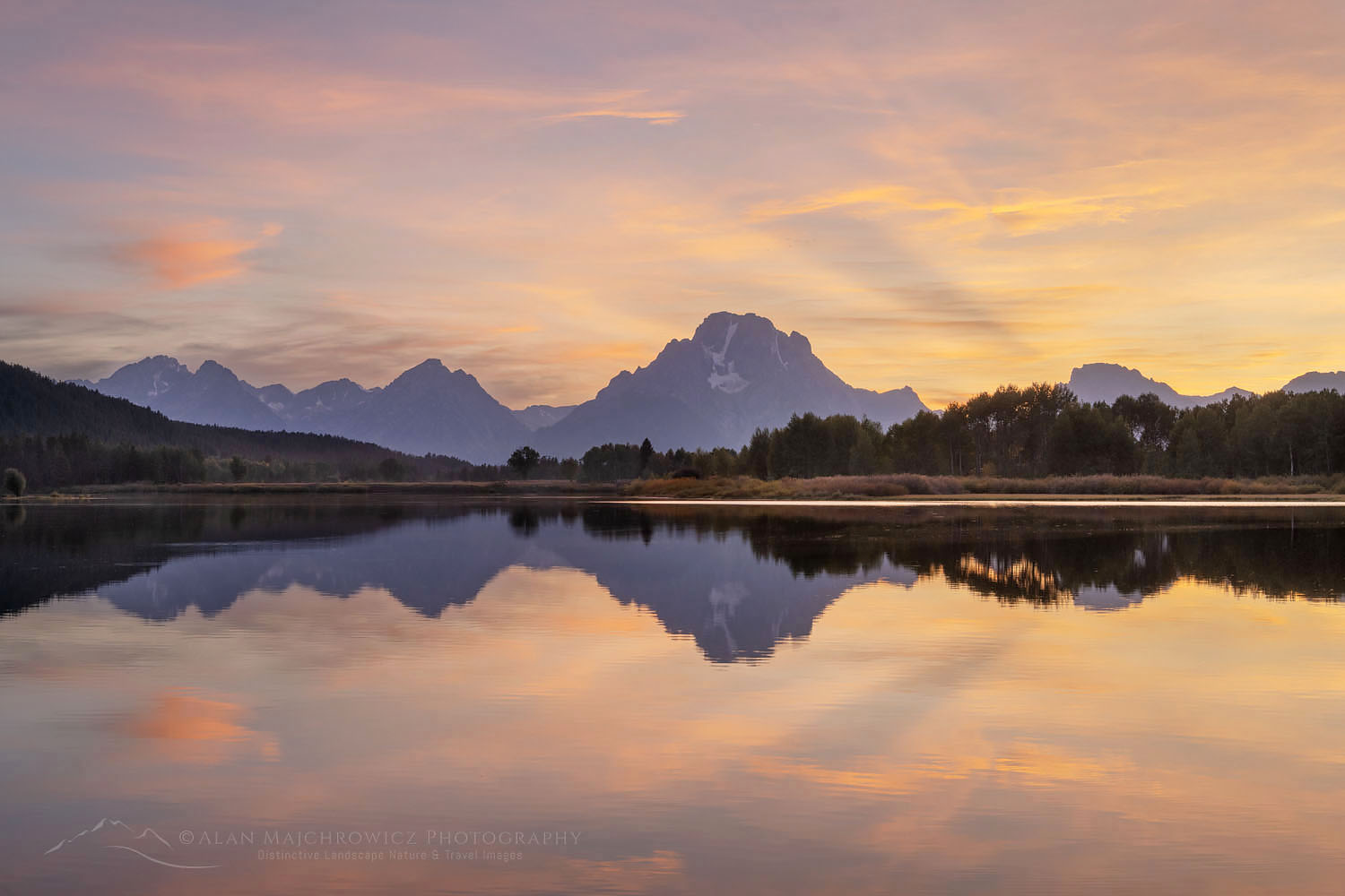 Mount Moran and clouds glowing red and orange in the light of the setting sun reflected in still waters of the Snake River at Oxbow Bend, Grand Teton National Park Wyoming #67575