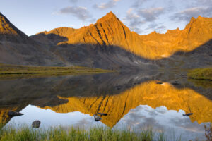 Peaks of the Tombstone Range reflected in Grizzly Lake, Tombstone territorial Park Yukon Canada