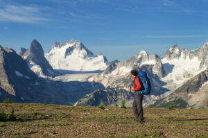 Backpacker admiring view on Rocky Point Ridge. Howser Towers, Vowell Glacier, and Northern Bugaboos in the distance. Bugaboo Provincial Park Purcell Mountains British Columbia. #62896