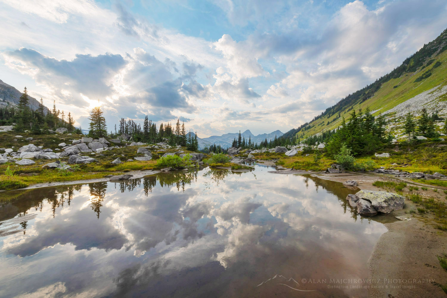 Dramatic clouds reflected in a stream in the alpine basin of Mount Rohr. Coast Range, British Columbia