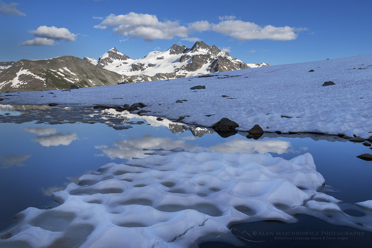Snow melt tarn on Silent Mountain. Twin Towers, Cony Peak, and Spillimacheen Glacier are in the distance. Purcell Mountains, British Columbia #86134