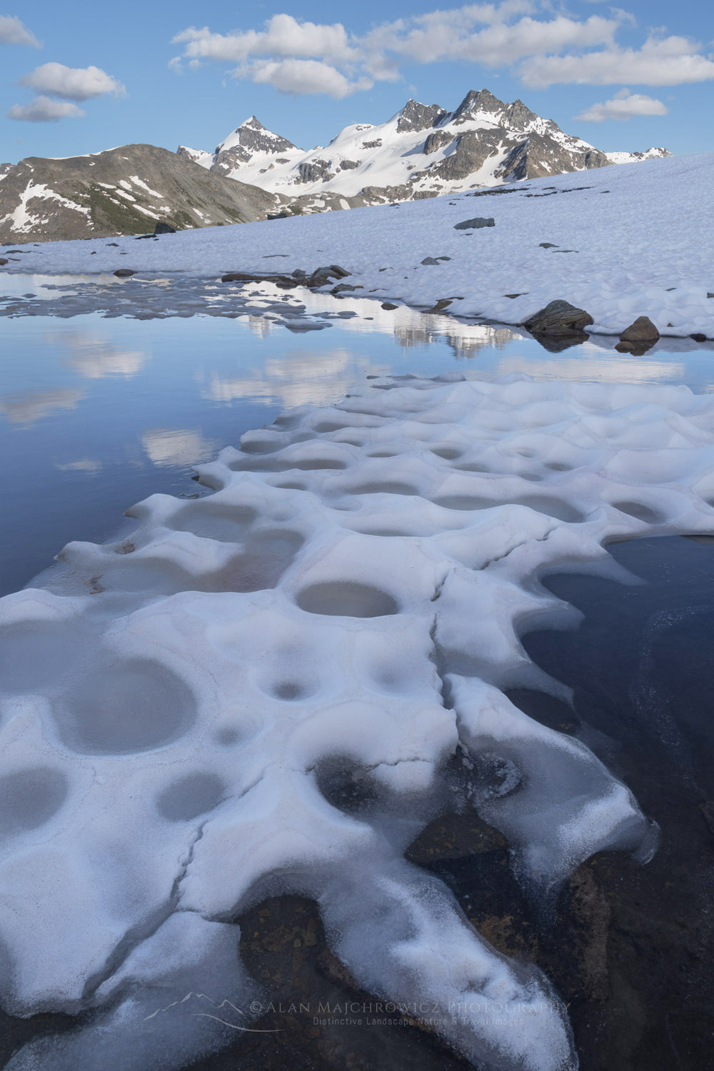 Snow melt tarn on Silent Mountain. Twin Towers, Cony Peak, and Spillimacheen Glacier are in the distance. Purcell Mountains, British Columbia #86137
